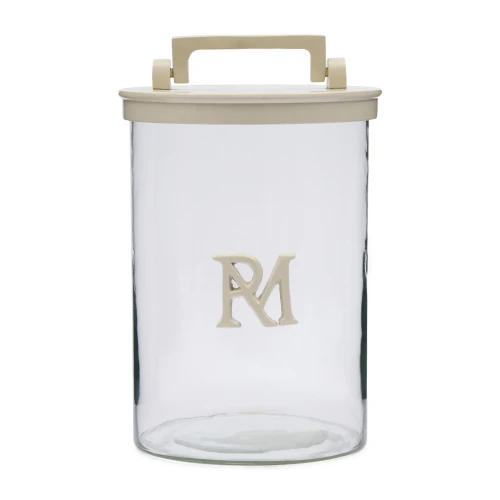 Słoik RM Monogram Riviera Maison, przezroczysty, z pokrywą w kolorze beżowym i uchwytem. Widoczny detal to logo RM w dolnej części słoika. Prezentowany frontalnie, stoi na białym tle, bez dodatkowych dekoracji. Idealny do przechowywania.