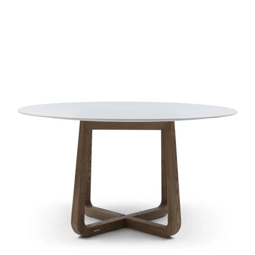 Okrągły stół jadalniany Casone Riviera Maison o średnicy 140 cm i wysokości 78 cm, z białym blatem z materiału imitującego marmur oraz drewnianą, brązową podstawą w kształcie krzyża. Ujęcie frontalne, na jednolitym tle.