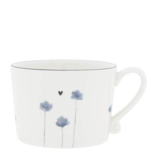 Kubek Iris Blue Poppy z kolekcji Bastion wykonany z białej ceramiki. Na ściankach widoczne delikatne niebieskie kwiaty oraz małe serce. Formowany do góry, z lekko zaokrągloną rączką. Prezentowany frontalnie, na prostym tle.
