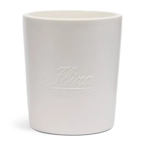 Świeca zapachowa Ibiza Scented Riviera Maison w białym, matowym cylindrycznym pojemniku z wytłoczonym logo Ibiza i napisem RIVIERA MAISON na froncie, stojąca na prostym tle, podkreślającym elegancki wygląd.