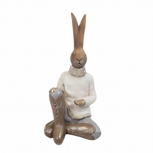 Figurka zająca (39 cm) w białym swetrze z kołnierzem, siedzi z nogą na nodze, trzyma złotą kulę. Ma brązowe buty z detalami. Zdjęcie frontalne na białym tle.