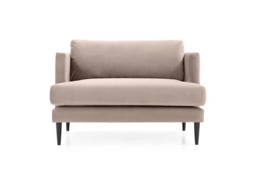 Mała sofa Eveline w odcieniu beżu, tapicerowana gładkim materiałem. Ujęcie frontalne, produkt o kompaktowych wymiarach 112x86x78 cm, z niskimi, czarnymi nogami. Bez widocznych guzików czy wzorów, idealna do małych wnętrz.