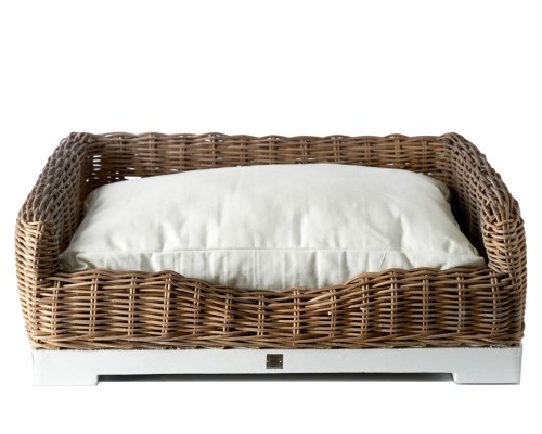 Stylowe legowisko dla psa Rustic Rattan Riviera Maison z plecionym, jasnobrązowym rattanem i kremowym, miękkim wypełnieniem. Ujęcie frontalne. Produkt leży na białym tle, podkreślając jego estetykę. Wymiary i detale nie są widoczne w zdjęciu.