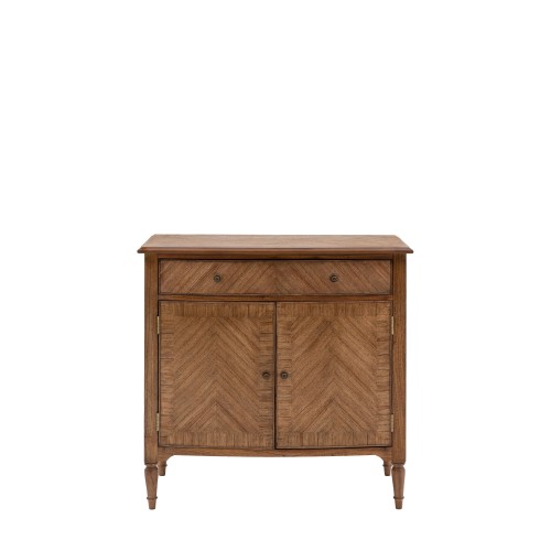 Brązowa komoda drewniana Highgrove o wymiarach 100x48x95 cm, z dwoma drzwiczkami z wzorem w jodełkę i jedną szufladą. Stojąca na smukłych nóżkach, z metalowymi uchwytami. Prosta, elegancka forma, idealna do aranżacji wnętrz.
