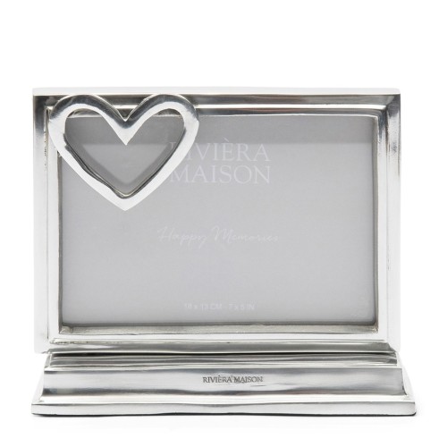 Ramka na zdjęcia Heart 18x13 cm Riviera Maison w kolorze srebrnym, z dekoracyjnym sercem po lewej stronie. Prosta konstrukcja z podstawą, idealna do wyeksponowania wspomnień. Widoczne napisy Happy Memories oraz logo marki.