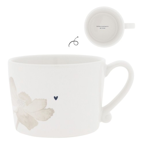 Kubek ceramiczny w kolorze białym, ozdobiony subtelnym motywem kwiatu w odcieniach szarości oraz małym sercem w kolorze granatowym. Posiada wygodny uchwyt i widoczny napis little moments of love wewnątrz. Ujęcie frontalne.