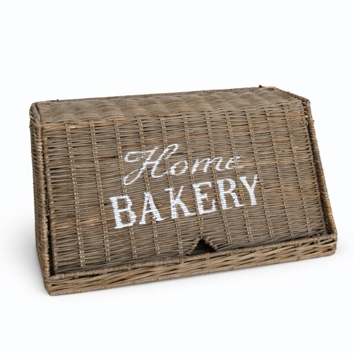 Rattanowy chlebak w odcieniu szaro-brązowym, z białym napisem Home Bakery. Produkt zamknięty, z klapą otwierającą się z przodu, o prostokątnym kształcie, idealny do przechowywania pieczywa w kuchni.