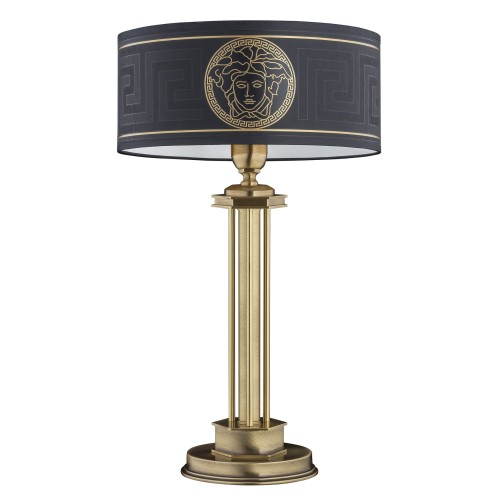Lampa stołowa o wysokości 51 cm z okrągłym kloszem w kolorze czarnym, z złotym wzorem przedstawiającym twarz, osadzona na metalowej, złotej podstawie. Ujęcie frontalne, lampa stoi na płaskiej powierzchni.