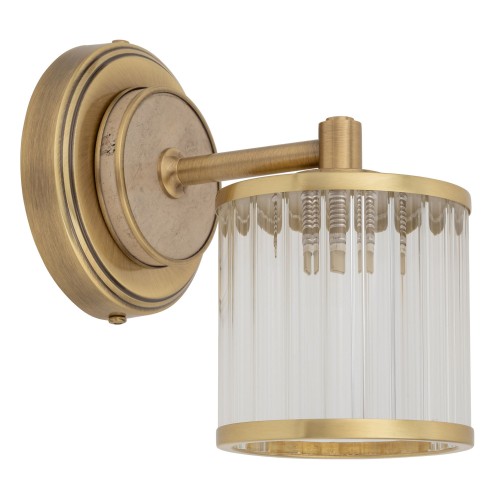 Kinkiet Como II w kolorze złotym, o wymiarach 12x12x20 cm. Lampa ma szklaną klosz z pionowymi żłobieniami i metalową podstawę. Ujęcie z boku ukazuje detal montażu oraz elegancki design, idealny do różnych aranżacji wnętrz.