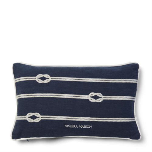 Granatowa poduszka dekoracyjna Nordic Knot o wymiarach 50x30 cm, z białymi wzorami w postaci sznurków i węzłów. Widoczny napis RIVIERA MAISON na dolnej części poduszki. Produkt leżący na prostym tle.