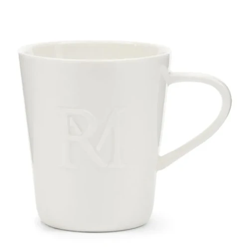 Biały kubek ceramiczny o prostym, lekko zaokrąglonym kształcie z wyraźnym, wytłoczonym monogramem RM. Stoi w pozycji pionowej, z uchwytem po prawej stronie, na neutralnym tle. Idealny do codziennego użytku.