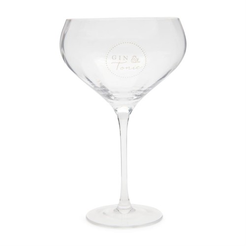 Kieliszek do gin and tonic z przezroczystego szkła, o dużej, zaokrąglonej czaszy i długiej nóżce. Na ściance widoczny napis GIN & Tonic otoczony kropkowanym wzorem. Stoi na płaskiej, okrągłej podstawie, na jasnym tle.