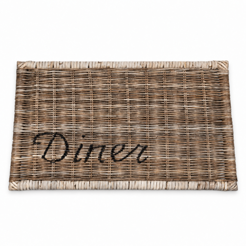 Rattanowa podkładka na stół w odcieniach brązu i beżu, z wyraźnym napisem Diner na jednej stronie. Produkt leży na białym tle, z widoczną teksturą plecionki. Idealna do stylizacji stołu w jadalni lub na tarasie