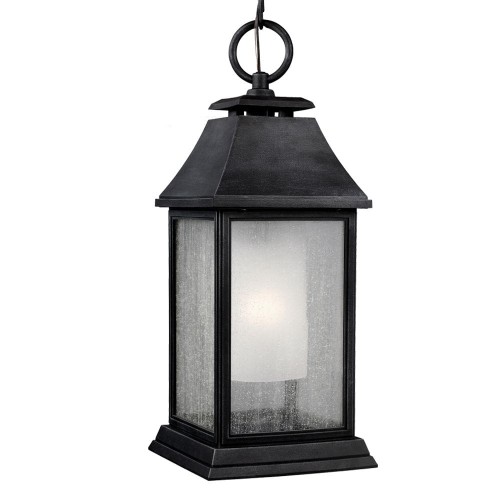 Lampa wisząca 21,6x53,7 cm z czarnego metalu, sześciokątna, przeszklona, na okrągłym uchwycie. Widok frontalny na źródło światła i matowy klosz wewnętrzny. Jednolite tło.