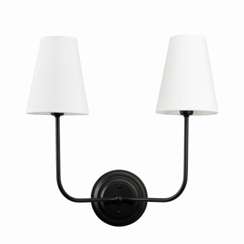 Kinkiet w stylu Modern Farmhouse, podwójny, czarny. Wysokość 41 cm, z dwoma białymi abażurami o stożkowym kształcie. Produkt zamontowany na ścianie, uchwyty w formie prostych ramion przytrzymujących klosze, na jednolitym tle.