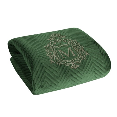 Personalizowana narzuta z haftem w ciemnozielonym kolorze, o teksturze aksamitnej, z wzorem jodełki. Produkt leży na boku, z wyróżniającym się haftowanym monogramem. Idealna do aranżacji wnętrz.