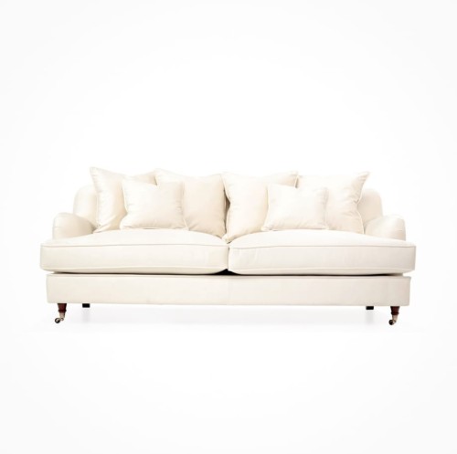 Trzyosobowa sofa Brighton w kolorze białym o wymiarach 215x102x84 cm. Prezentowana z przodu, z lekko zaokrąglonymi podłokietnikami i pięcioma miękkimi poduszkami. Podstawa na metalowych nogach, prosty kształt, elegancka tkanina tapicerska.