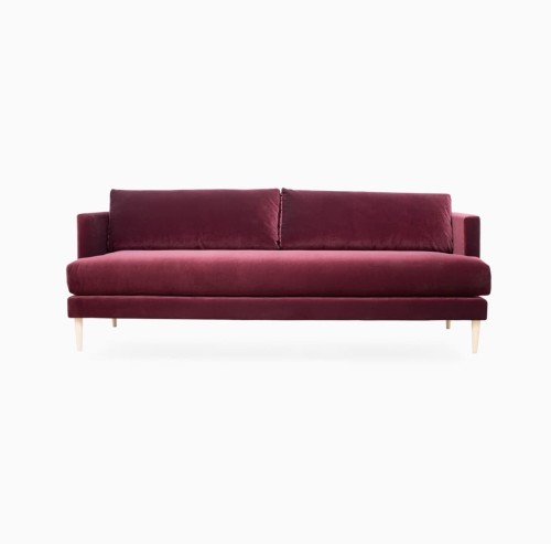 Trzyosobowa sofa Edmo, bordowa, 210x87x80 cm, z miękkimi poduszkami prostokątnymi, na drewnianych nóżkach. Aksamitna tkanina nadaje elegancki wygląd.