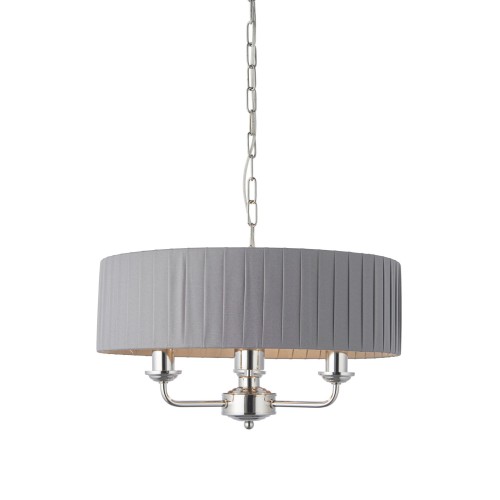 Lampa sufitowa wisząca Highclere w kolorze szarym z tkaniny o strukturze plisowanej. W centralnej części metalowy korpus niklowy z trzema źródłami światła. Produkt zawieszony na łańcuchu, widok frontalny. Wysokość lampy wynosi 142 cm.