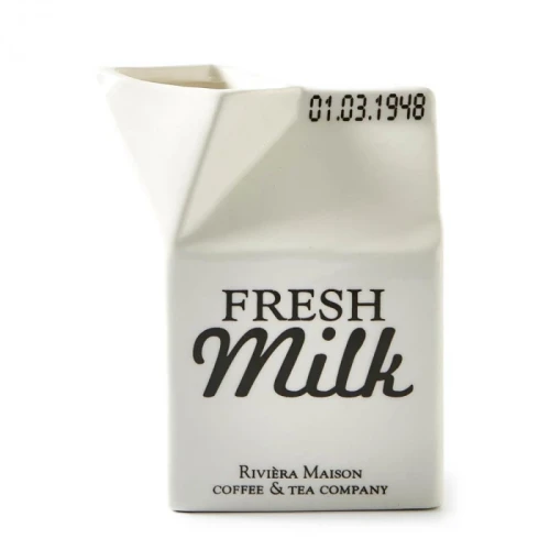 Pojemnik na mleko Carton Riviera Maison w kolorze białym, o kształcie zbliżonym do kartonu, z widocznym napisem FRESH Milk w czarnym kolorze. Produkt stoi w pozycji frontalnej, prezentując detalicznie krawędź oraz lekko zaokrąglony dzióbek.