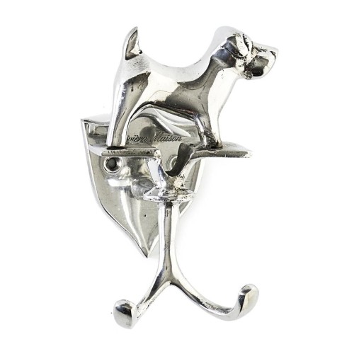 Wieszak Happy Dog Riviera Maison w kształcie psa, wykonany z metalowego materiału w kolorze srebrnym. Produkt montowany na ścianie, z dwoma haczykami do zawieszania. Zbliżenie na szczegóły, logo na powierzchni. Proste, białe tło.
