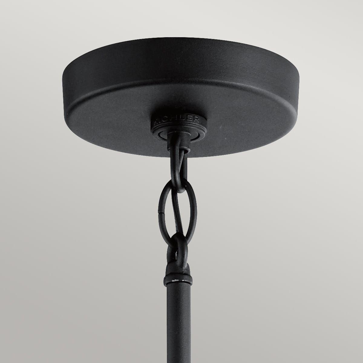 Wisząca latarnia Como z teksturowaną czernią, ukazana z dołu. Widoczna metalowa osłona sufitowa oraz łańcuch mocujący, tworzący minimalistyczny, industrialny styl. Produkt zawieszony, podkreślający elegancję przestrzeni.