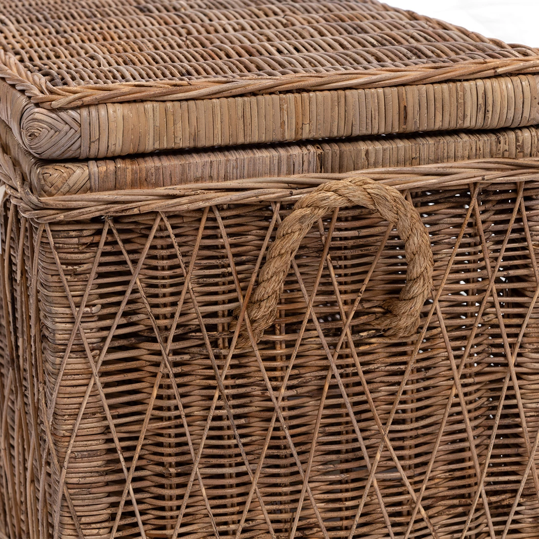 Rattanowy kufer Nusa Dua M w kolorze naturalnym, o wymiarach 94x42x45 cm, z widoczną plecionką oraz uchwytem z jutowego sznura. Ujęcie z boku, produkt zamknięty, ukazujący detale wzoru oraz strukturę materiału.