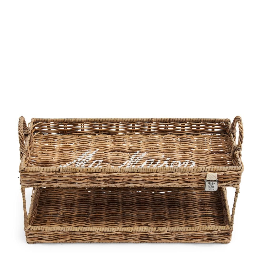 Tacka Ma Maison Double Riviera Maison, wykonana z wikliny, o długości 40 cm. Produktem prezentowanym w ujęciu frontalnym, z widocznymi uchwytami. Wewnętrzna część ułożona w prosty wzór, z napisem Ma Maison w kolorze białym na powierzchni.
