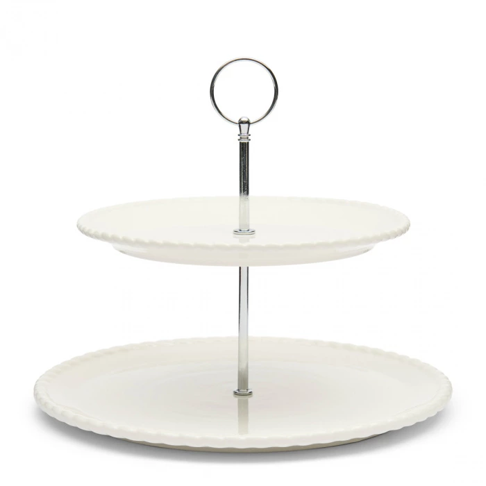 Biała etażerka Elegant Twist Riviera Maison z dwoma poziomymi talerzami, wykonana z ceramiki. Posiada metalowy uchwyt w górnej części. Ujęcie frontalne, produkt stoi na płasko, talerze mają faliste brzegi. Proste tło podkreśla elegancję.