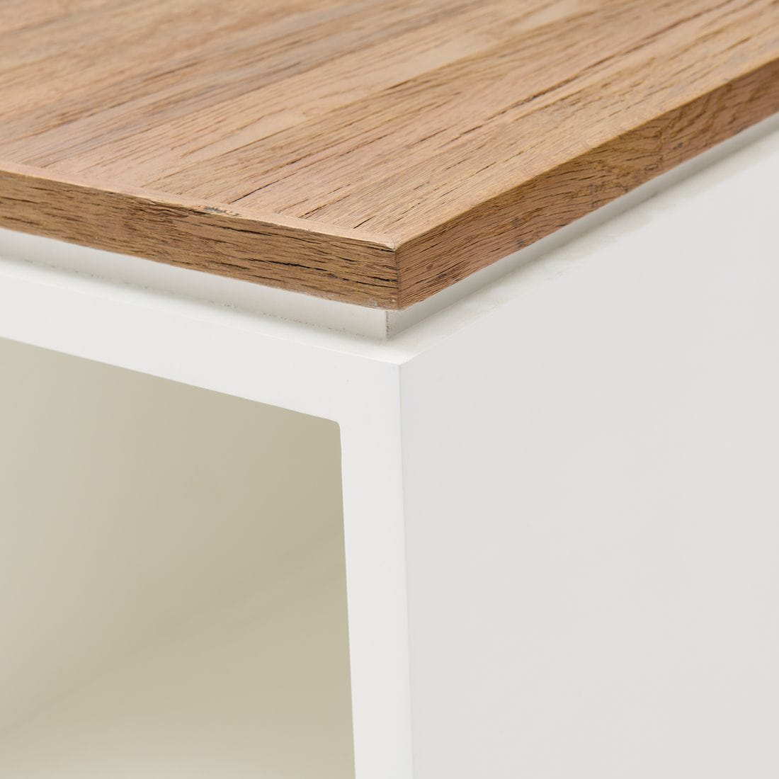 Stolik kawowy Lake House Riviera Maison z białą podstawą i prostokątnym blatem w kolorze naturalnego drewna. Produkt widoczny z góry, ukazujący krawędź blatu. Wymiary 100x40x45 cm. Prosta, minimalistyczna forma bez dodatkowych dekoracji.