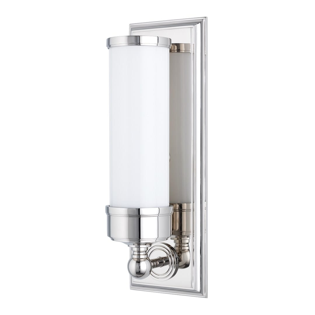 Klasyczny kinkiet Everett w kolorze chromowanym, z białym mlecznym kloszem w kształcie cylindrycznym. Produkt zamontowany na ścianie, widoczny z boku. Srebrna, metalowa oprawa z dekoracyjnymi detalami, zapewniająca elegancki wygląd.