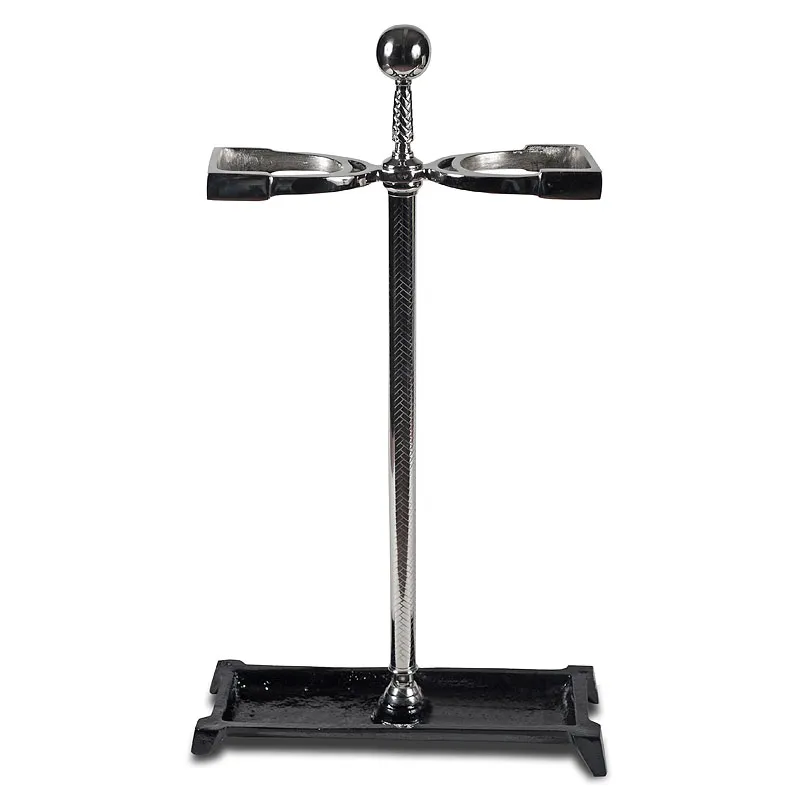 Stojak na parasole o wysokości 71 cm, wykonany z metalu w kolorze srebrnym, z podstawą w czerni. Produkt stoi prosto, ma okrągłą, przeszkloną głowicę oraz dwie poprzeczne półki na parasole. Szczegółowy wzór na metalowej rurze.