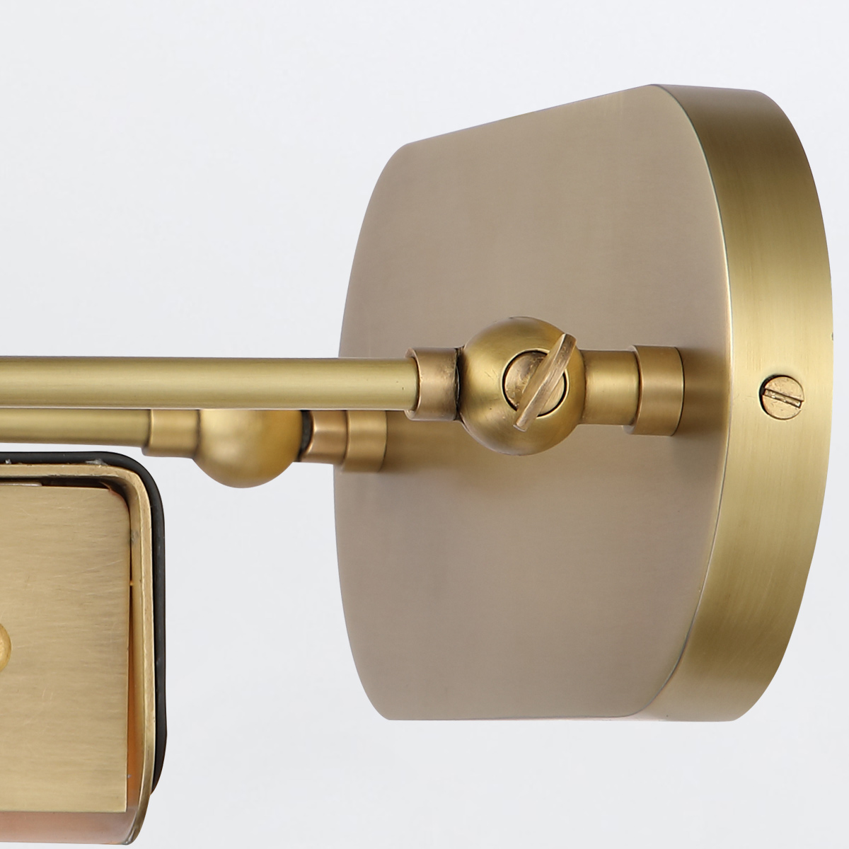 Średnia lampka LED w stylu vintage w kolorze mosiądzu. Ujęcie frontalne, zbliżenie na mocowanie i obrotowy przegub przy ścianie. Gładka powierzchnia, minimalistyczny design, brak widocznych napisów lub logo. Jasne, neutralne tło.