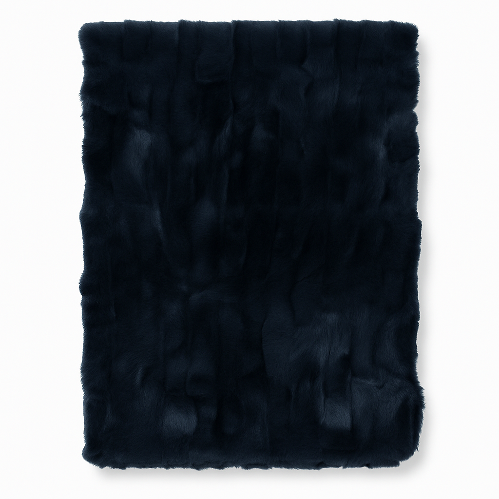 Granatowy pled Elias Faux o wymiarach 180x130 cm, wykonany z miękkiego futerka. Produkt leży na jasnym tle, prezentując gładką teksturę i głęboki kolor. Idealny do dekoracji wnętrz lub jako ciepły dodatek na chłodne dni.