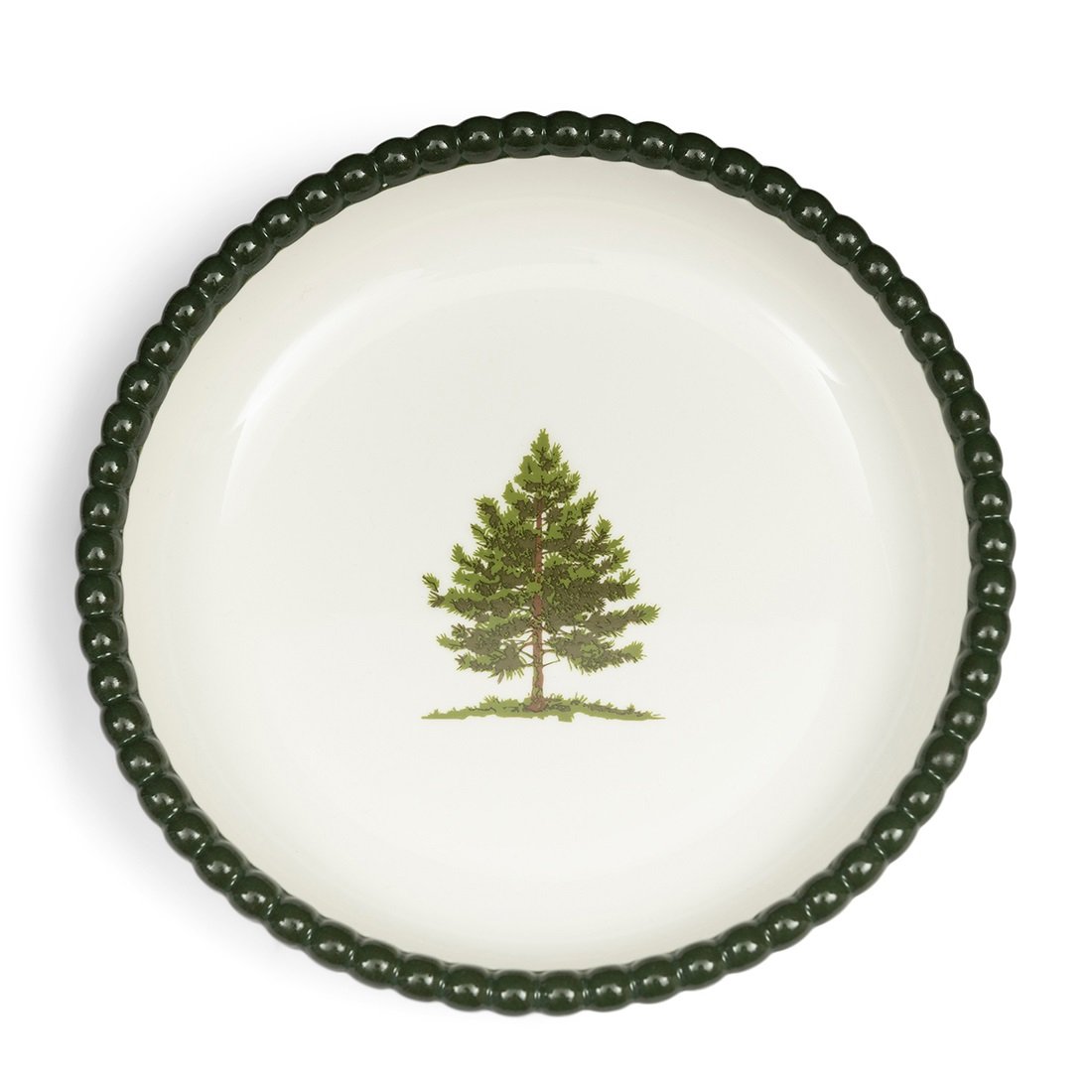 Miseczka Woodlands Tree Bowl Riviera Maison w kolorze białym z zielonym, perełkowym brzegiem. Na dnie widoczny rysunek drzewa iglastego. Produkt stojący, ukazany z góry, idealny do serwowania przekąsek lub dekoracji stołu.