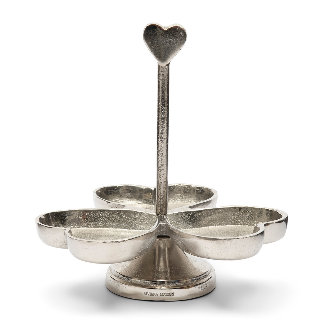 Etażerka Happy Heart Riviera Maison w kształcie kwiatka z trzema płatkami, wykonana z metalu w srebrnym kolorze. Na górze znajduje się uchwyt w formie serca. Produkt stoi na okrągłej podstawie. Tło białe, co podkreśla elegancki wygląd.