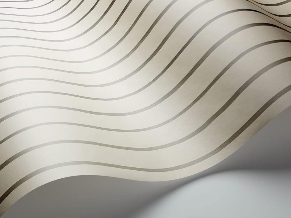 Tapeta Cole and Son College Stripe w odcieniach bieli i srebra, z falistym wzorem w drobne, równoległe paski. Ujęcie w zbliżeniu, ukazujące fakturę materiału. Tło proste, jasno szare. Produkt przeznaczony do dekoracji wnętrz.