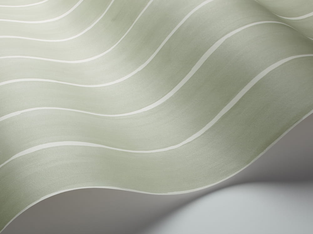 Tapeta Cole and Son Marquee Stripe w kolorze białym i zielonym, prezentująca faliste pasy. Widok z bliska, ukazujący fakturę materiału i delikatny połysk. Produkt luźno ułożony na jasnym tle, podkreślający wzór oraz kolorystykę.
