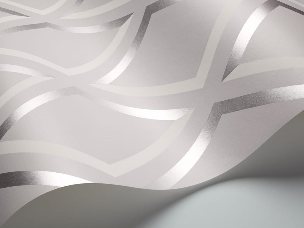 Tapeta Cole and Son Pompeian White/Silver/Soft Grey o wzorze falistym, w kolorze białym ze srebrnymi akcentami. Produkt leży na gładkim tle, prezentując teksturę materiału oraz subtelną, metaliczną połyskliwość.