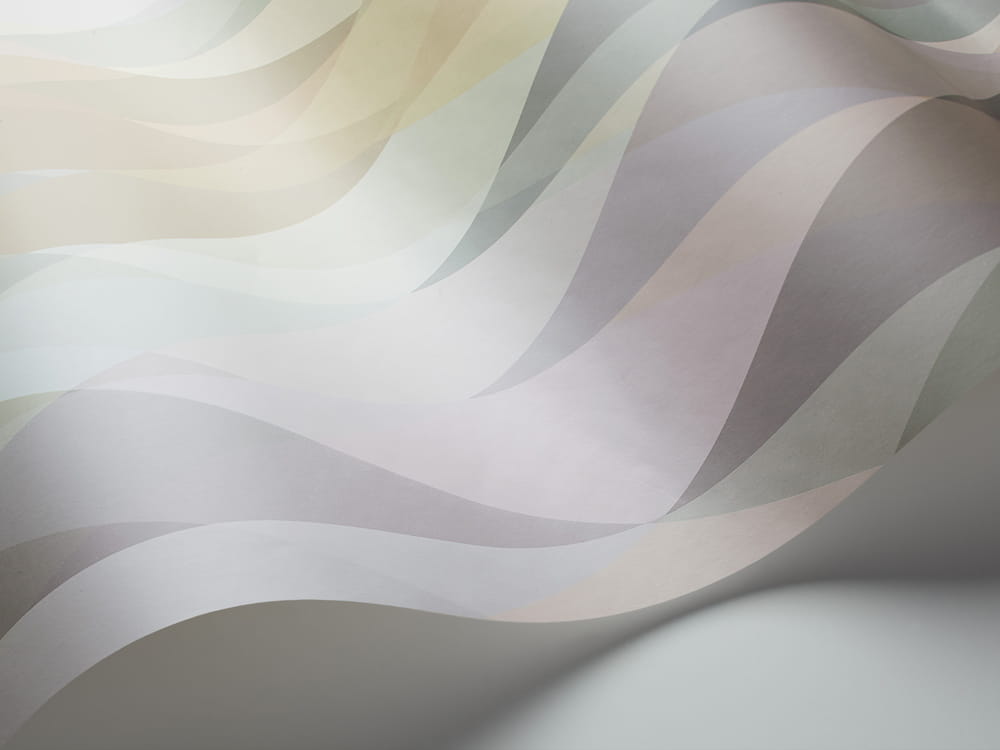 Tapeta Cole and Son Prism Pastel Multi w odcieniach pastelowych, z falistym wzorem. Ujęcie z boku, ukazujące delikatne przejścia kolorów: różowy, błękitny i beżowy. Produkt leży na gładkiej powierzchni, tworząc efekt trójwymiarowości.
