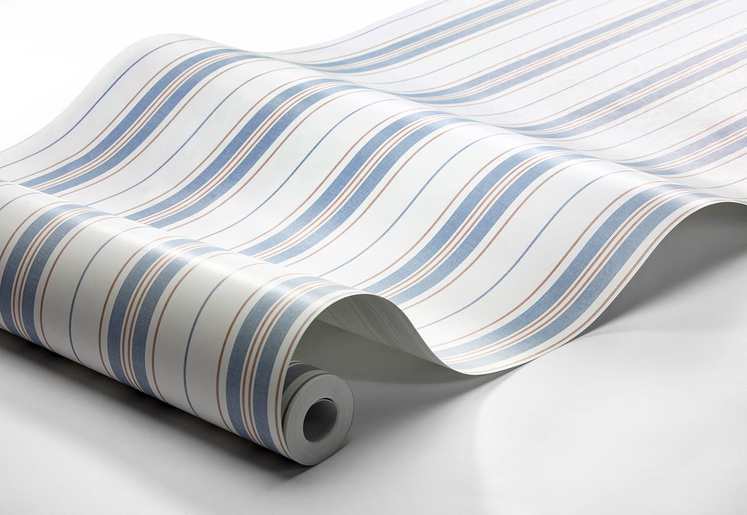 Tapeta Marstrand II Hamnskar Stripe w kolorze niebieskim, białym i czerwonym, z falistym wzorem. Produkt leży na białym tle, zwinięta z rolki, ukazując różnorodne szerokości pasków i gładką teksturę materiału.