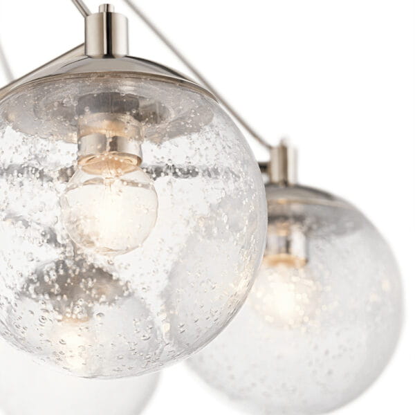 Lampa sufitowa Assi M w kolorze niklowym z trzema szklanymi kloszami o okrągłym kształcie. Klosze mają przezroczystą fakturę z drobnymi bąbelkami. Produkt wiszący, uchwycony z góry, eksponuje źródła światła wewnątrz kloszy.