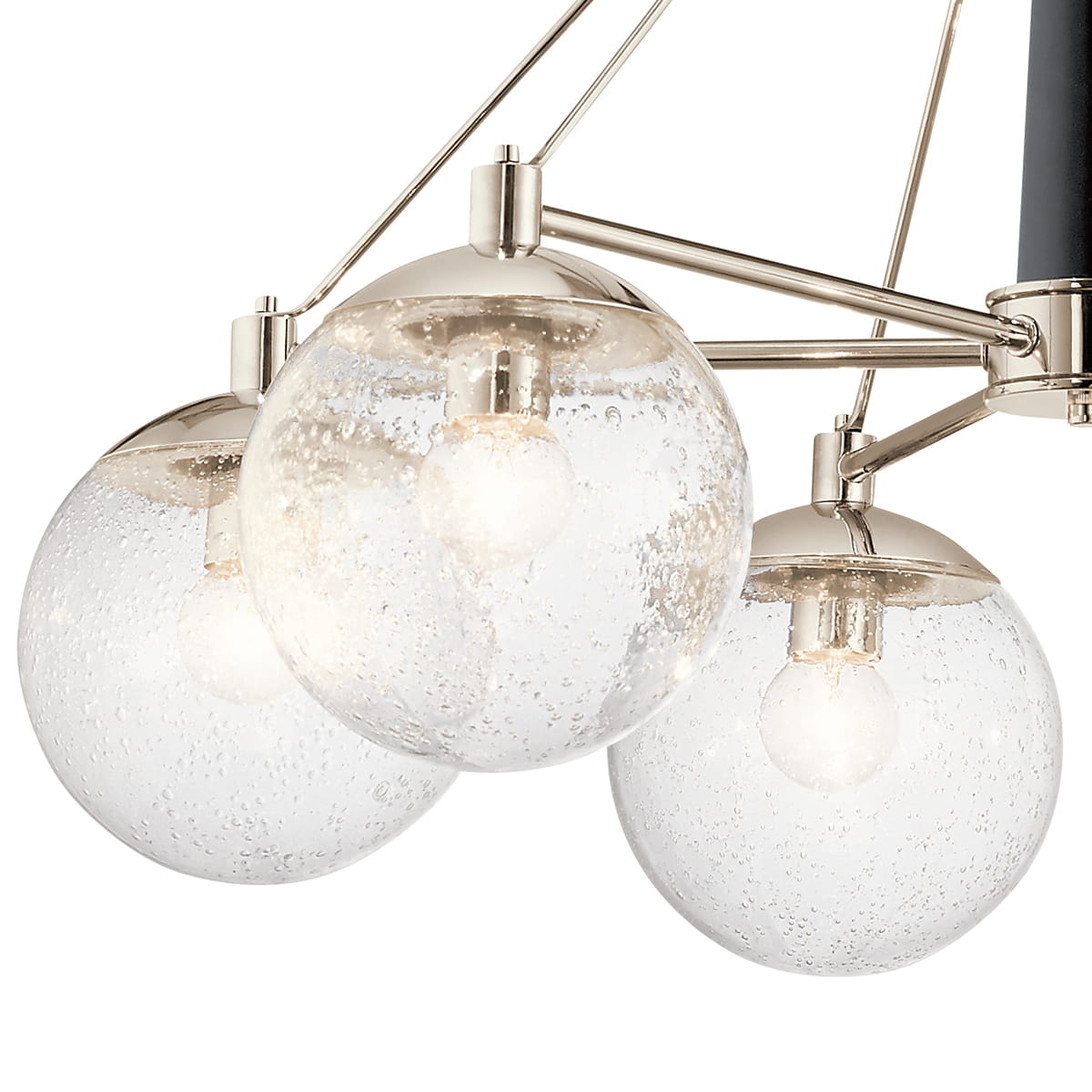 Lampa sufitowa Assi L w kolorze niklowym z trzema szklanymi kloszami o bąbelkowej fakturze. Klosze są okrągłe, z widocznymi żarówkami. Produkt wisi na metalowych ramionach, z czarnym elementem u góry. Wymiary: 63,5x87,6x71 cm.