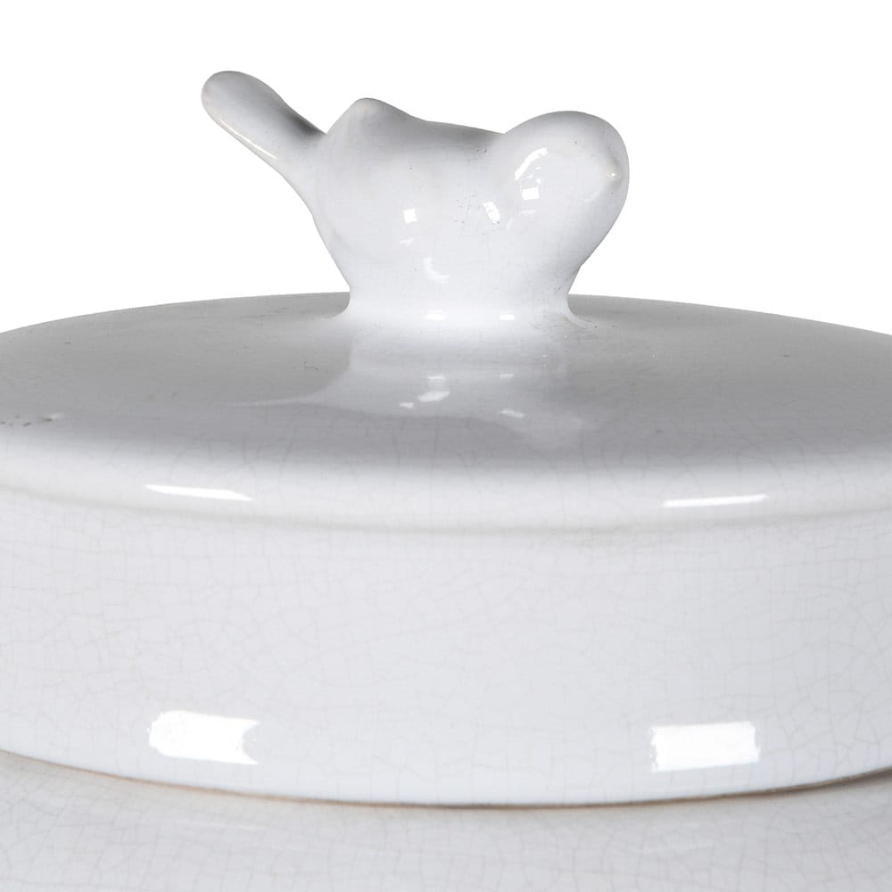 Ceramiczna waza amfora w kolorze białym z krótkim, dzióbkowym uchwytem na pokrywie. Zbliżenie na górną część produktu, ukazujące delikatną fakturę i błyszczącą powierzchnię. Wysokość 35 cm. Prosta prezentacja na jasnym tle.