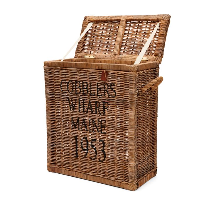 Rattanowy kosz w kolorze naturalnego brązu o wymiarach 60x30x70 cm, z napisem COBBLER'S WHARF MAINE 1933. Produkt otwarty, z widocznym wnętrzem i uchwytami po bokach. Wzór tkacki nadaje mu teksturę. Ekspozycja frontalna, na jednolitym tle.