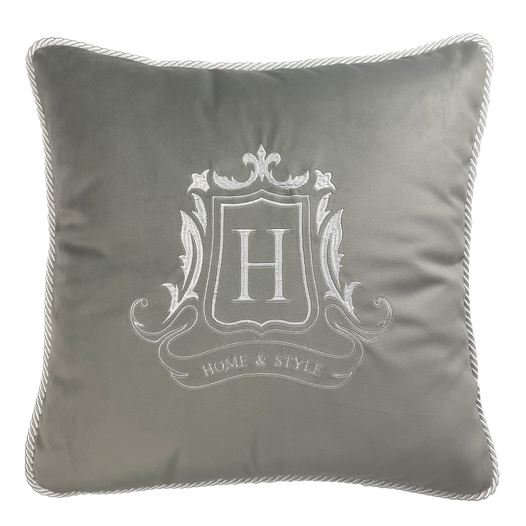 Poduszka dekoracyjna w odcieniu szaro-srebrnym, z haftem monogramu „H” oraz napisem „HOME & STYLE”. Zdjęcie przedstawia produkt leżący na białym tle, z widoczną delikatną fakturą materiału oraz dekoracyjnym obszyciem.