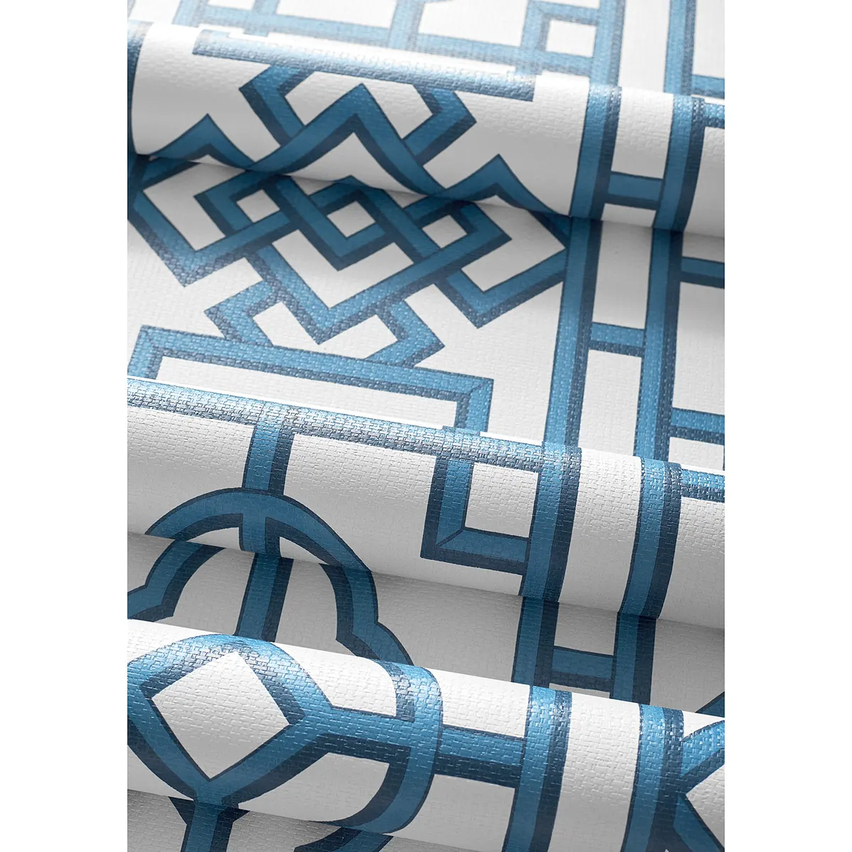 Tapeta Thibaut Anna French GATEWAY w kolorze szmaragdowym z geometrycznym wzorem w odcieniach niebieskiego, zbliżenie na detal. Produkt leży na białym tle, pokazując połyskującą fakturę oraz kontrastujące linie i kształty.