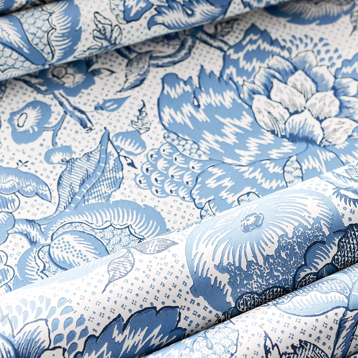 Tapeta Thibaut Anna French WESTMONT w jasno niebieskim odcieniu z florystycznym wzorem. Produkt leży na płasko, ukazując detale kwiatowe oraz subtelne kropki w tle. Materiał jest gładki, a wzór rozciąga się na całej powierzchni.
