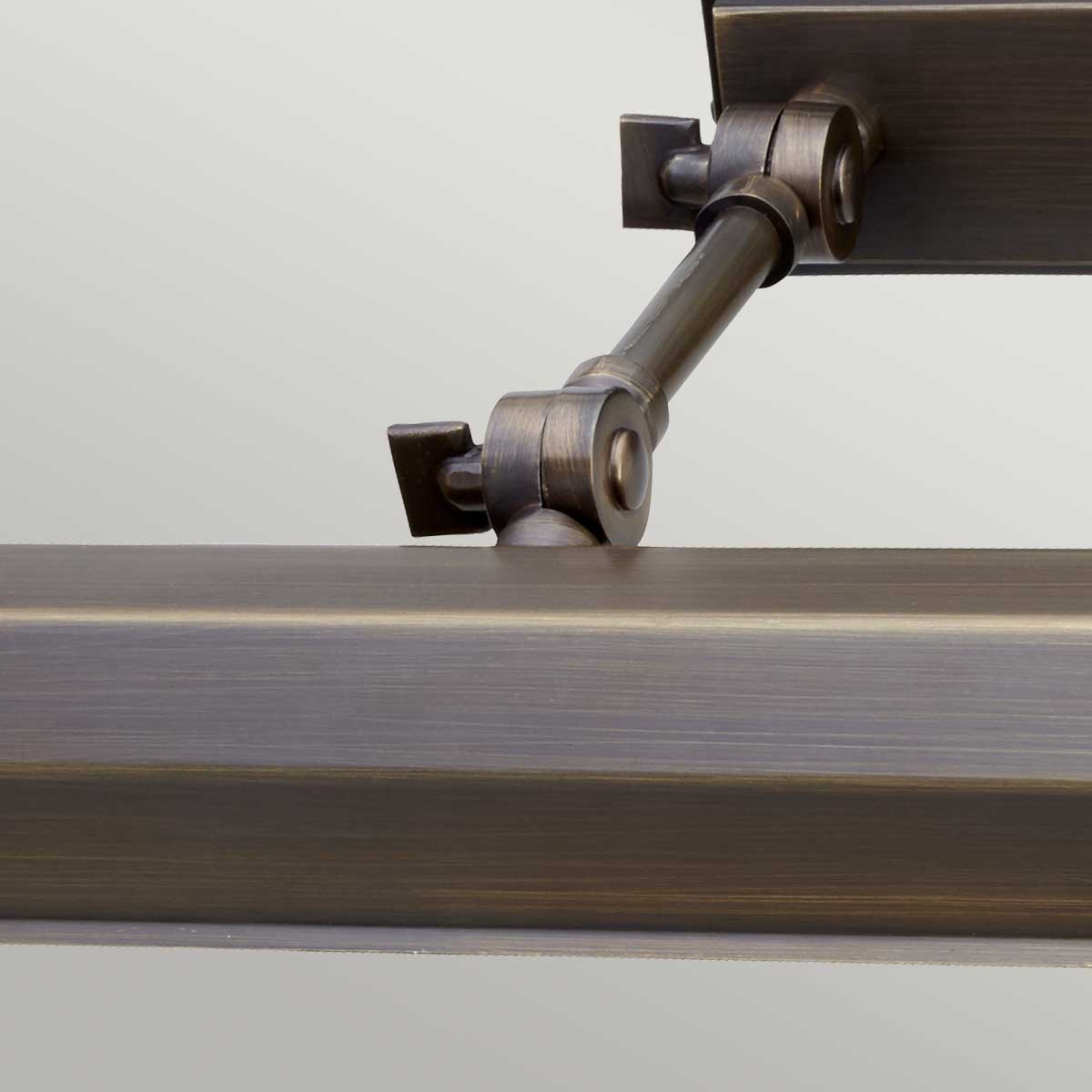 Zbliżenie na Kinkiet Galeryjka Canvas XL w kolorze brązowym. Widoczny detal montażowy oraz stelaż z metalicznym wykończeniem. Całość na jasnym tle, co podkreśla subtelne faktury i kształt lampy. Produkt wiszący, o eleganckim designie.