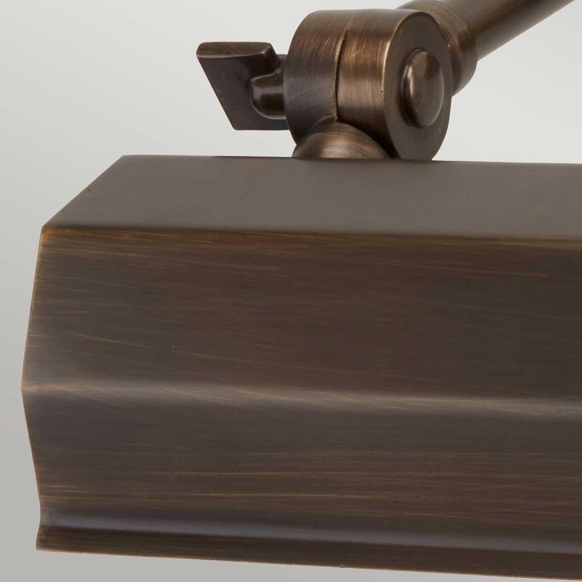 Kinkiet Canvas S w kolorze brązowym, widok z boku zbliżony na mocowanie. Produkt wykonany z metalu, z minimalistycznym, prostokątnym abażurem i regulowanym ramieniem. Umożliwia punktowe oświetlenie w aranżacjach wnętrz.